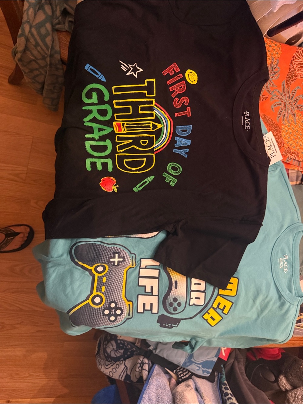 2 size 14 Children's Place t-shirts one black “first day” one green gamer.